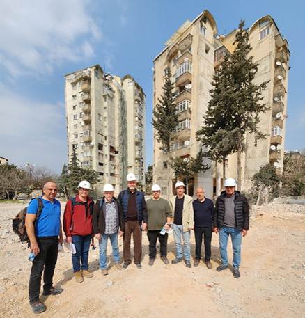 A group of people standing in front of a building

AI-generated content may be incorrect.